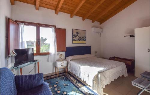 a bedroom with a bed and a tv and a couch at Beautiful Apartment In Riola Sardo With Wifi And 2 Bedrooms in Riola Sardo