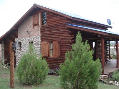 a log cabin with trees in front of it at Azul in Arroyo de Los Patos