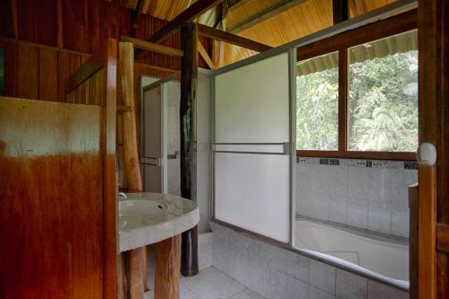 baño con lavabo, bañera y ventana en Ecoamazonia Lodge, en Puerto Maldonado