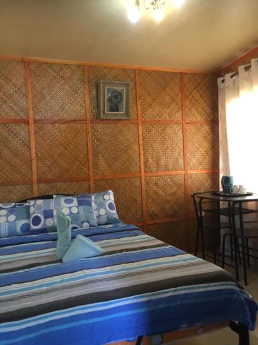 a bedroom with a bed with a blue comforter at Hope Inn in Bolod