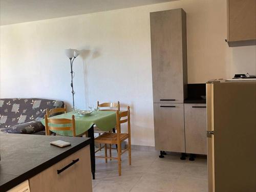 une cuisine et une salle à manger avec une table et des chaises dans l'établissement Appt 2 pièces avec piscine et parking, à 850m de la plage - FR-1-229D-110, à Fleury