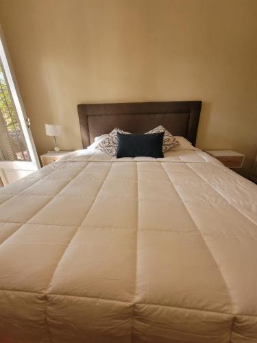 a large white bed with a blue pillow on it at 816 B&B in Mendoza