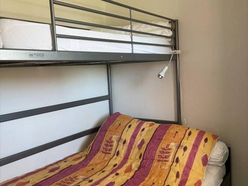 - une chambre avec des lits superposés et un couvre-lit dans l'établissement Appt 2 pièces avec piscine et parking, à 850m de la plage - FR-1-229D-110, à Fleury