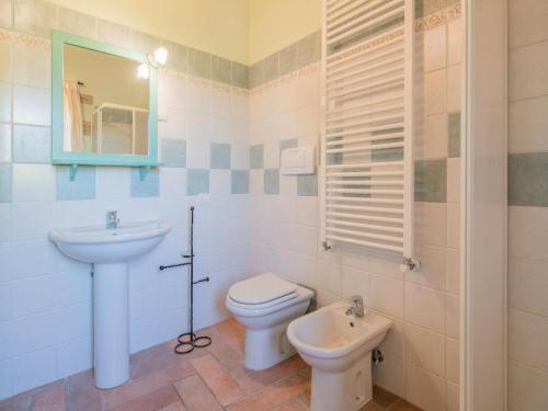 a bathroom with a sink and a toilet and a mirror at Holiday Home in Sellano with Pool & Sun Terrace in Sellano
