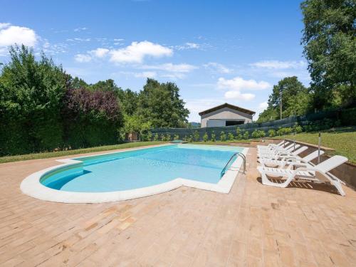 een zwembad met witte stoelen ernaast bij Quiet holiday home in Sellano with swimming pool a few kilometers from Rasiglia in Sellano