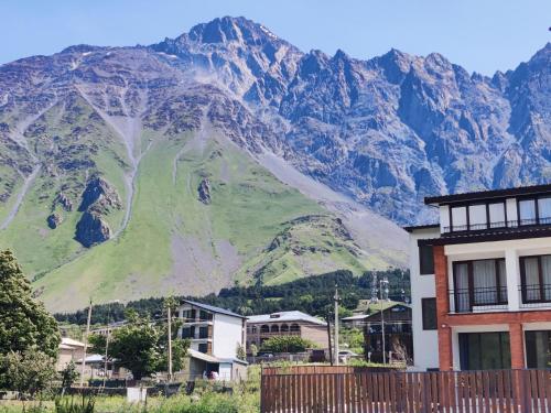a mountain in the background of a city with houses at Royal Galaxy in Kazbegi