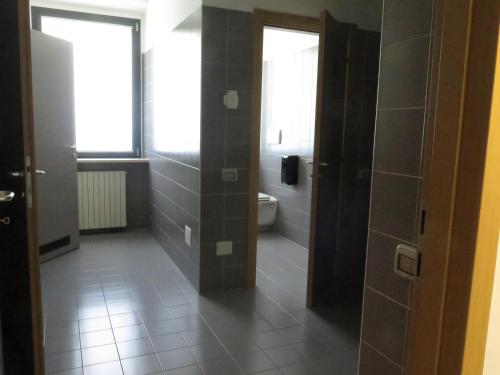 La salle de bains est pourvue de toilettes, d'une fenêtre et d'une porte. dans l'établissement Ostello La Mine, à Cogne