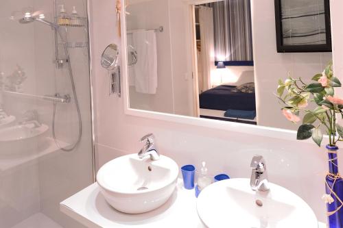 a bathroom with two sinks and a shower and a mirror at Maison d'Hôtes Bleu Azur in Tourrettes-sur-Loup