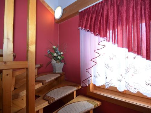 a room with chairs and a window with red walls at Ruhiges Ferienhaus in Drachselsried in Waldnähe in Drachselsried