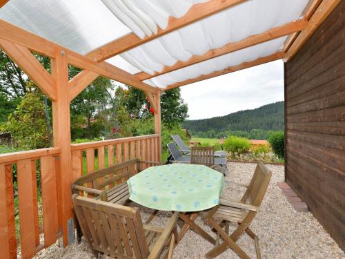 a patio with a table and chairs under a pergola at Ruhiges Ferienhaus in Drachselsried in Waldnähe in Drachselsried