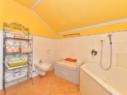 a bathroom with a tub and a toilet and a sink at Ruhiges Ferienhaus in Drachselsried in Waldnähe in Drachselsried