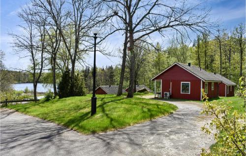 a small red house with a pole in the grass at Lake Front Home In Asarum With Kitchen in Asarum