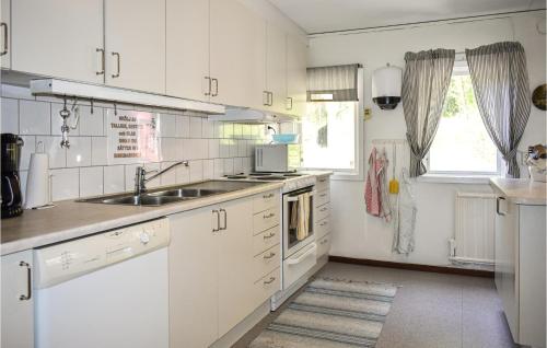 a kitchen with white cabinets and a sink and a window at Lake Front Home In Asarum With Kitchen in Asarum