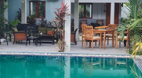 a patio with a table and chairs next to a pool at Tiger Shark Residence & Dive in Fuvahmulah