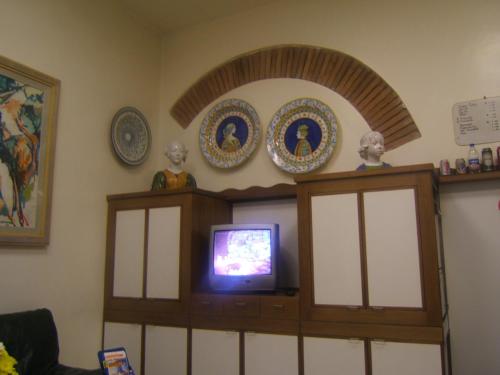 a living room with a tv and some plates on the wall at Hotel Nuova Italia in Florence