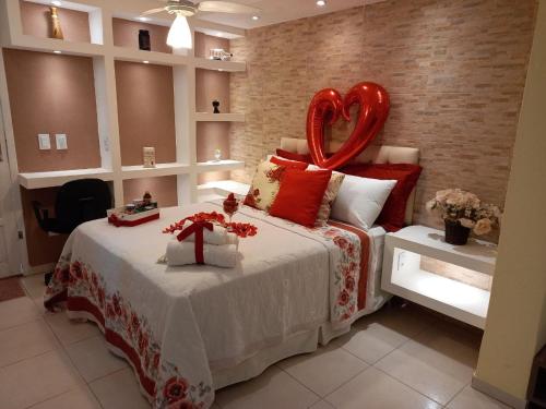 a bedroom with a bed with a large red heart overhead at Suite Requinte da Serra in Miguel Pereira