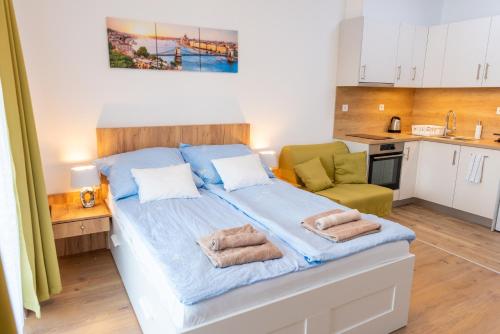 ブダペストにあるSWEET HOME Apartman , 30sqm studio, free private parking, mountain view, balcony, 20 min from downtownの小さなベッドルーム(ベッド1台付)、キッチンが備わります。