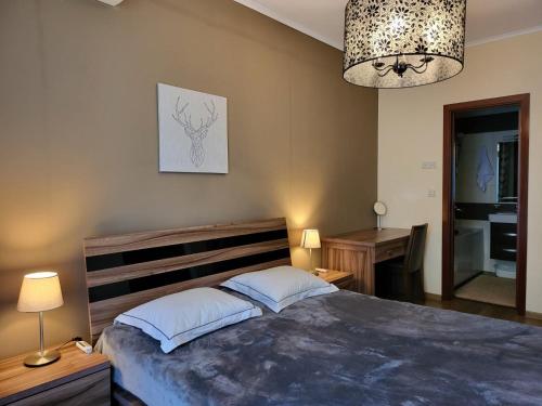 Un dormitorio con una cama grande y una lámpara de araña. en Europroperties Golden Line, en Golden Sands