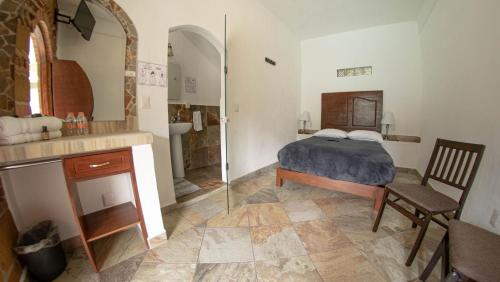 a bedroom with a bed and a bathroom with a shower at La Buena Suerte in Tepoztlán