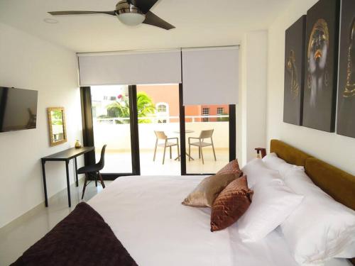 1 dormitorio con 1 cama blanca y comedor en Elegant apartment well located in the hotel zone of Cancun, en Cancún