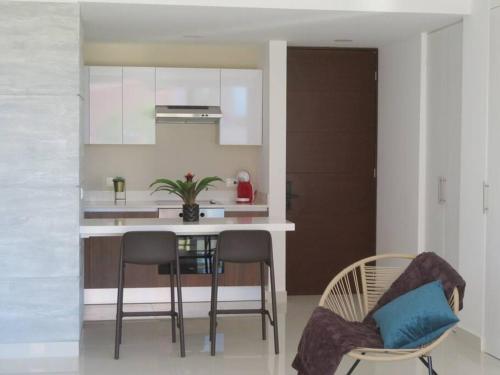 a kitchen with a table and chairs in a room at Elegant apartment well located in the hotel zone of Cancun in Cancún
