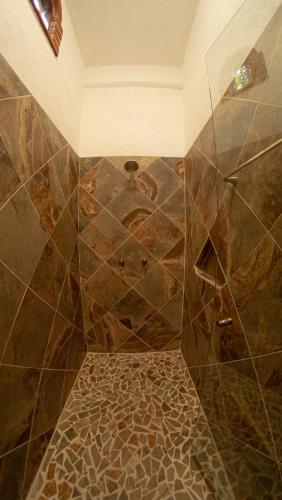 a bathroom with a shower with a tiled floor at La Buena Suerte in Tepoztlán