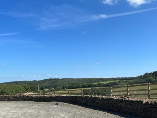 a stone wall with a fence and a field at Number One - The Old Stables in Wadebridge