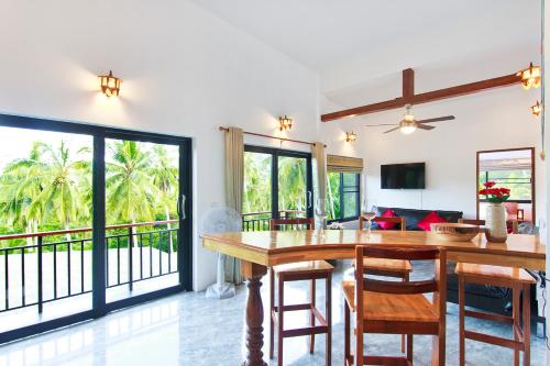a dining room and living room with a table and chairs at 2 Bays Villa in Thong Nai Pan Yai