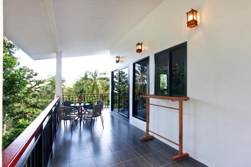a balcony of a house with a table and chairs at 2 Bays Villa in Thong Nai Pan Yai