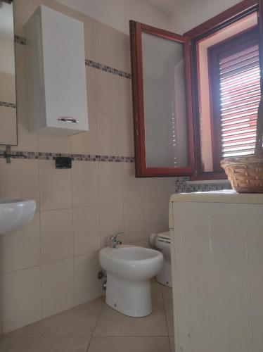 a bathroom with a toilet and a sink at Profumo di mare in Càbras