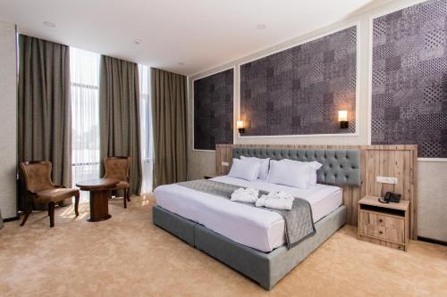 een hotelkamer met een bed, een bureau en stoelen bij Gabrielle International Hotel in Tasjkent
