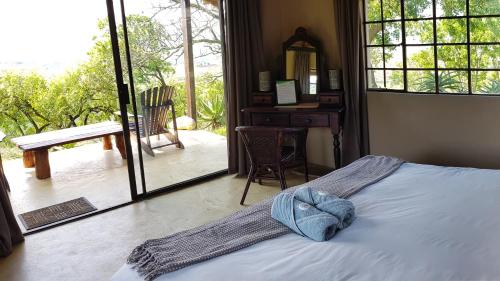 a bedroom with a bed with a hat on it at Wide Horizons Mountain Retreat in Malkerns