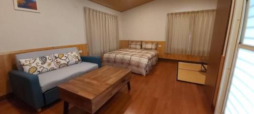 a bedroom with a bed and a couch and a table at Wind Valley Homestay in Lugu Lake