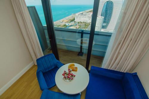 a table and two chairs in a room with a view at Batumi City Apartments in Batumi