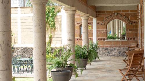 an outdoor patio with columns and tables and chairs at La Buena Suerte in Tepoztlán
