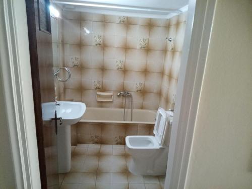 een badkamer met een bad, een toilet en een wastafel bij Tom House 1 in Filiatra