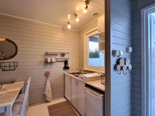 a small kitchen with a sink and a table at Domki z jacuzzi nad zatoką in Puck