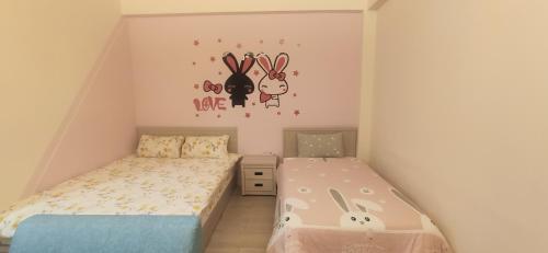 a small bedroom with a bed and a sticker of rabbits at Xiangsheng Homestay in Puli