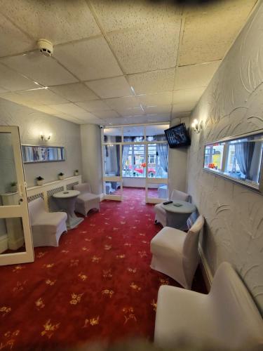 a waiting room with white chairs and a red carpet at Novello Blackpool in Blackpool