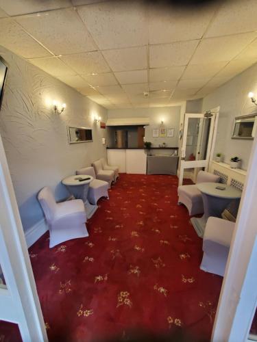 a waiting room with white chairs and red carpet at Novello Blackpool in Blackpool