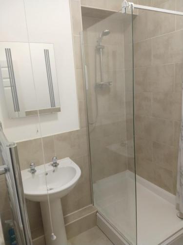 ein Bad mit einer Dusche und einem Waschbecken in der Unterkunft All Saints 2 bed Apartment in central Stamford with Parking in Stamford