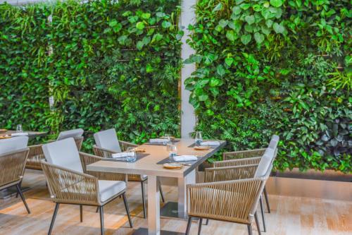 a restaurant with a green wall with tables and chairs at Pan Pacific Beijing in Beijing