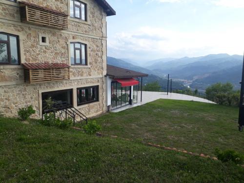 a stone house with a view of the mountains at Hayat Oksijen Resort in Ordu
