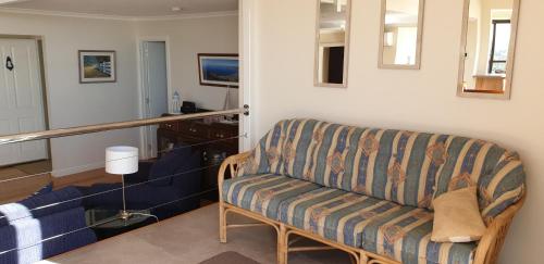 a living room with a couch and a staircase at A Sweet Escape in Bridport