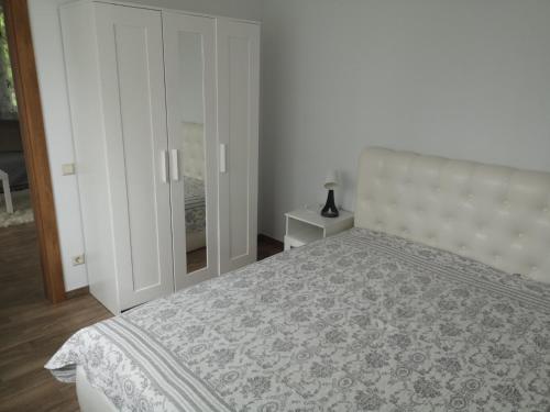 a bedroom with a large bed and a cabinet at Kristinos apartment in Druskininkai
