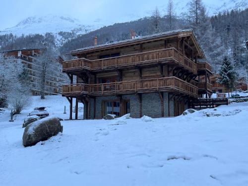 a large wooden log house in the snow at Polaris appartement 2 in Zinal