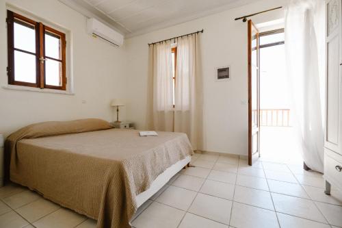 a white bedroom with a bed and a window at Villa Luce in Halki