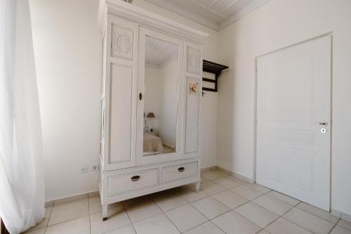 a white cabinet in a white room with a door at Villa Luce in Halki