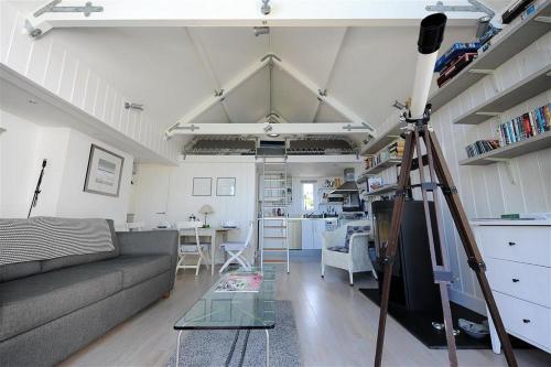 un salon avec un canapé et une table dans l'établissement Little West Hill Studio, à Lyme Regis