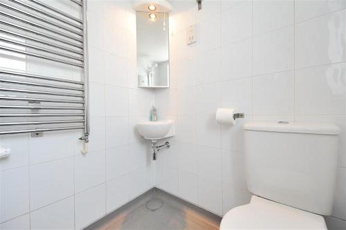 une salle de bains blanche avec toilettes et lavabo dans l'établissement Little West Hill Studio, à Lyme Regis